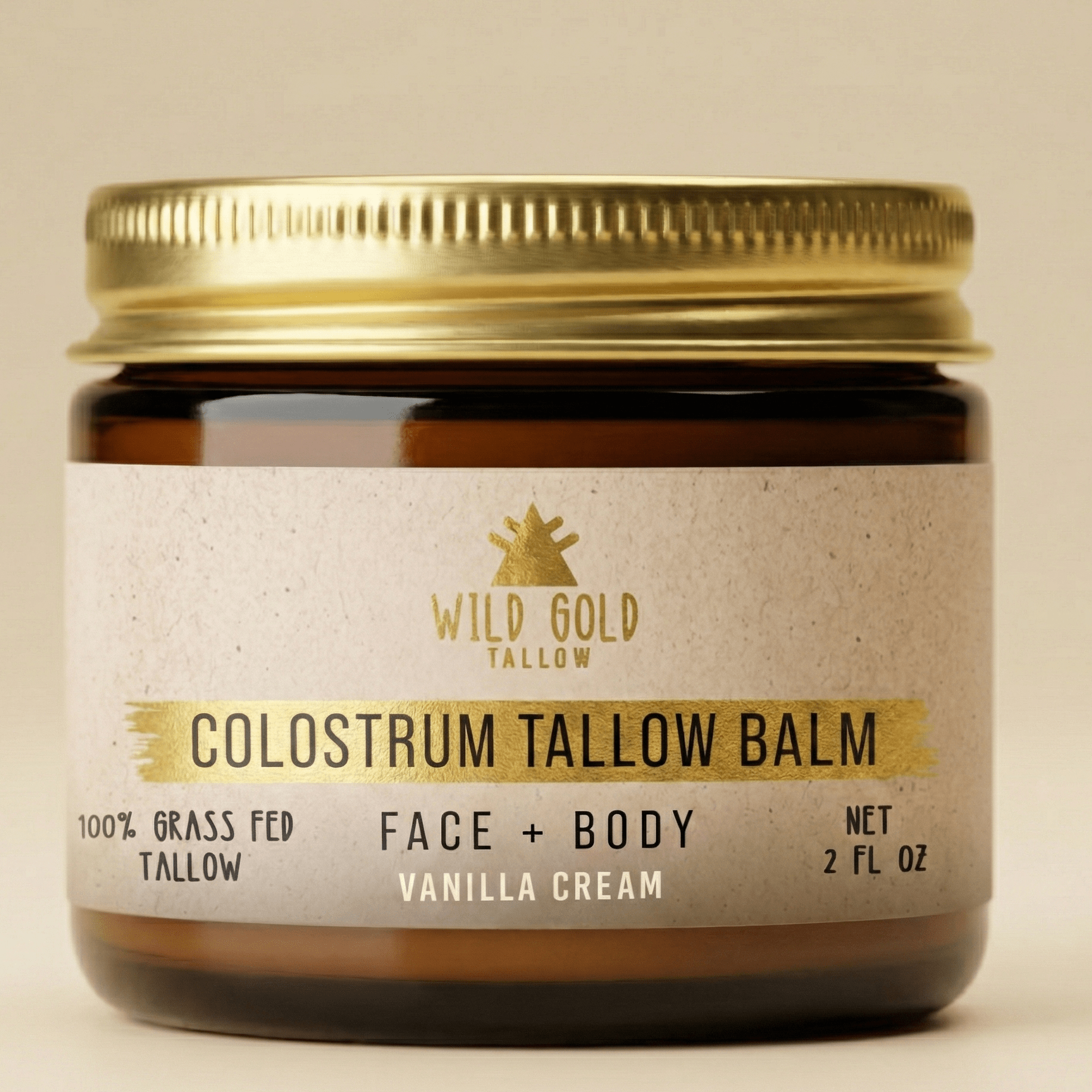 Jar of Wild Gold Tallow Colostrum Tallow Balm with a gold lid on a beige background